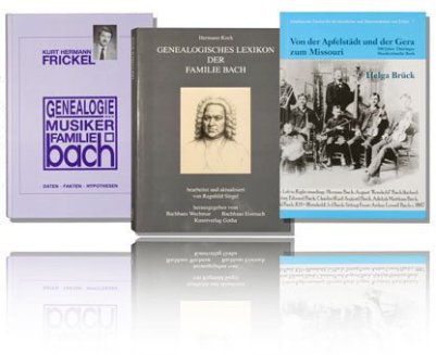 Three Bach genealogy books are hovering in front of white background and a mirror on the bottom. The left book is purple, the book in the middle is black/white and the right is light blue, all about the genealogy of the Johann Sebastian Bach Familily.